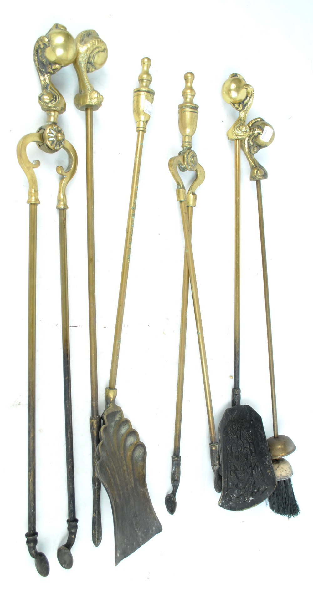 A four piece brass companion set with ball and claw handles, a further pair of tongs and shovel,