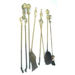 A four piece brass companion set with ball and claw handles, a further pair of tongs and shovel,