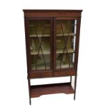 An Edwardian mahogany and inlaid display cabinet the moulded cornice above a pair of glazed doors