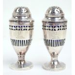 A pair of George III hallmarked silver urn shaped peppers with pierced domed covers,