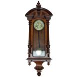 A 19th century walnut and stained beech Vienna wall clock with arched pediment set with circular