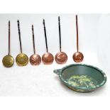 Six copper and brass bed warming pans with turned wooden handles and a barge ware floral decorated