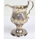 A George III hallmarked silver baluster cream jug with bead embossed rim and spreading circular