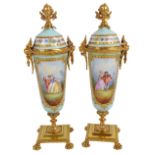 A pair of late 19th century Continental gilt metal mounted and gilt heightened porcelain urns,