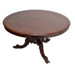 A Victorian mahogany circular breakfast table raised on lobed central column and three carved