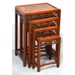 A nest of four Chinese hardwood occasional tables with carved vine decoration, largest 49 x 34cm.