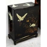 A 20th century Oriental black lacquer cabinet, hand-painted with cranes and bullrushes,