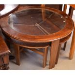 A retro nest of four circular tables comprising a large glass-topped table and three smaller tables.