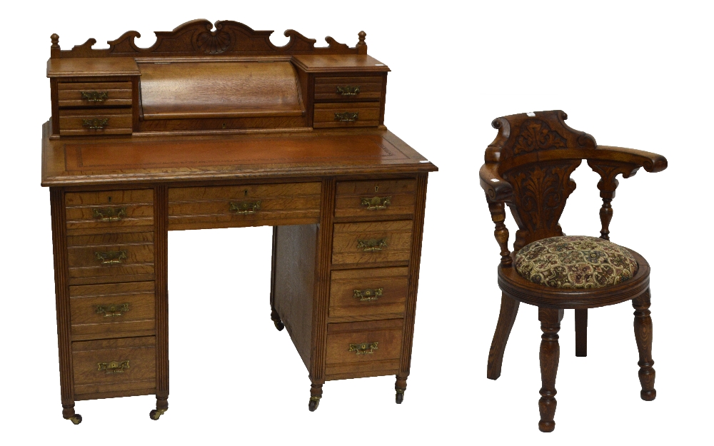 A late Victorian oak desk with raised superstructure with central frieze drawer and two further
