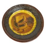An early 20th century Staffordshire slipware shallow bowl centred with a stylised cockerel,