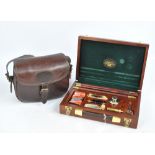 A Parker-Hale 12 bore cleaning kit in wooden presentation box and a leather cartridge bag with