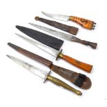 Three stiletto type knives with leather scabbards and a further knife with decorative wooden grip