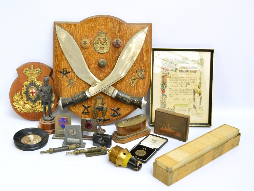 A quantity of mixed militaria to include a mounted pair of Gurkha kukri knives and related badges,