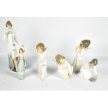 Three Lladro figures of winged cherubs, each with blue applied mark to face, the tallest 24cm.