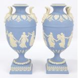 A pair of Wedgwood blue jasperware twin handled vases with classical relief decoration and square