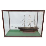 A glazed display case containing a model of a three masted vessel, length of cabinet 78.5cm.