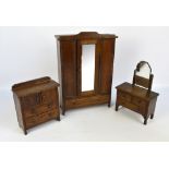 An early 20th century miniature oak three piece bedroom suite comprising a mirrored wardrobe,