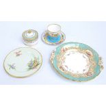 A Royal Worcester turquoise ground cup and saucer with painted floral, enamel and gilt decoration,