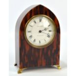An early 20th century tortoiseshell lancet shaped mantel time piece with circular white enamel dial