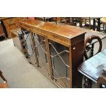 A reproduction mahogany bookcase with three astragal glazed doors and adjustable shelves to bracket