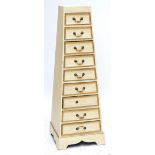 A reproduction painted pyramid shaped chest of nine short drawers raised on bracket feet,