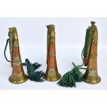 Three regimental bugles, two with cords and tassels, for Manchester, Cheshire and North Stafford,