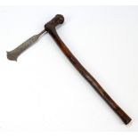 A late 19th/early 20th century tribal axe with shaped wooden shaft and iron blade, length 44cm.