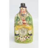 An early to mid-19th century reform flask modelled as a man seated upon a barrel,