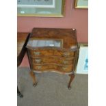 A reproduction walnut serpentine three drawer bedside chest on cabriole legs, width 52cm.