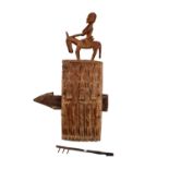 A Malian Dogon figural carved wooden granary door lock surmounted with a man seated upon a donkey,