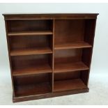 A reproduction mahogany open bookcase with dentil moulded cornice and two banks of drawers.