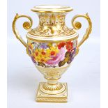 An early 19th century Bloor Derby gilt heightened floral painted twin handled vase raised on socle