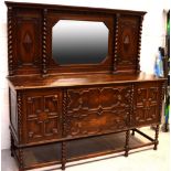 An early 20th century oak mirror and panel back sideboard with two central drawers flanked by