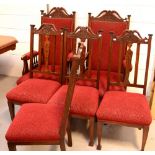 An Edwardian carved mahogany salon suite comprising two arm chairs and four chairs with red foliate