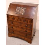 A mid-20th century oak Priory-style fall-front bureau, fitted interior with linen-fold carved front,