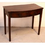 A Georgian mahogany bow-front hall table with two short drawers, raised on tapering square supports,