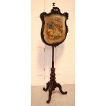 A Victorian mahogany pole screen with scrolling fauna-decorated frame,