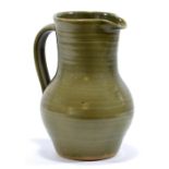 LEACH POTTERY; a stoneware lemonade jug covered in green glaze, impressed SI mark, height 24.5cm.