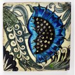 WILLIAM DE MORGAN; a square sectioned tile with stylised blue painted flower,