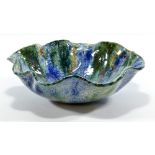 CAROLE SENDER; a bowl with wavy rim, highly decorated with radiating blue and green glaze,