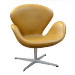ARNE JACOBSON for Fritz Hansen; a tan leather upholstered Swan chair raised on tubular frame,