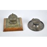 An early 20th century brass foliate scroll decorated inkwell on square sectioned wooden base,