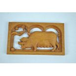ROGER SUTTON; a carved oak wall plaque centred with a pig, signed and dated 1993, 21 x 12cm.