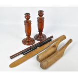 A small group of treen to include a pair of urn shaped candlesticks and a pair of pipe beaters (7).