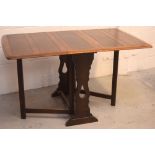 A 1940s oak drop-leaf dining table, length when extended 110cm,