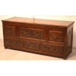 A late 18th/early 19th century oak housekeeper's chest of six drawers with profuse carving to the