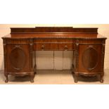 An Edwardian mahogany twin-pedestal inverted break-front sideboard,