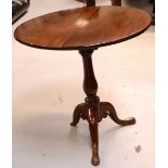 A 19th century mahogany circular tilt-top table raised on three scrolling supports,