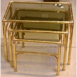 A nest of three 20th century lacquered brass graduated occasional tables each with a smoked glass