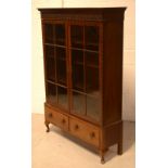 A 1920s mahogany two-door glazed bookcase with three adjustable shelves,